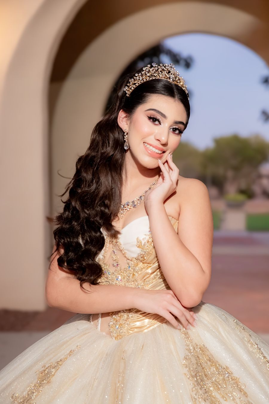 Quinceañera con tiara dorada, peinado y maquillaje de Karla Meza